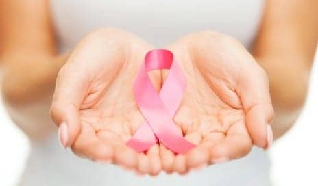 pink ribbon for breast cancer held in woman's hands